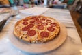 Baked pizza on stone plate sitting on kitchen island