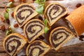 Freshly baked poppy roll with raisins, decorated with mint close-up on a table. horizontal top view Royalty Free Stock Photo