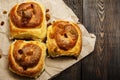 Freshly baked rolls with cinnamon with spices and raisins on parchment paper. View from above. Sweet homemade pastries. Close-up. Royalty Free Stock Photo