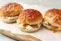 Freshly baked soda water scones with apricot jam and butter on table, closeup