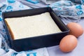 Freshly baked square sponge cake in baking dish, ingredients on background, horizontal Royalty Free Stock Photo