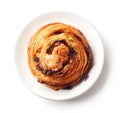 Sweet bun with raisins on white plate isolated on white, from above Royalty Free Stock Photo