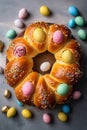 Freshly baked sweet Easter bread decorated with colorful chocolate eggs on wooden board top down view. Traditional holiday pastry