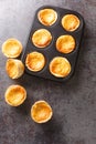 Freshly baked sweet Tarts Queijadas close-up in a baking dish. vertical top view