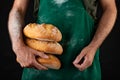 Freshly baked tasty bread in the baker& x27;s hands. Tasty baked goods straight from the bakery Royalty Free Stock Photo