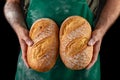 Freshly baked tasty bread in the baker& x27;s hands. Tasty baked goods straight from the bakery Royalty Free Stock Photo