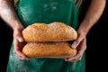 Freshly baked tasty bread in the baker& x27;s hands. Tasty baked goods straight from the bakery Royalty Free Stock Photo