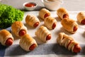 Freshly baked tasty sausage rolls on table