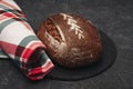 Freshly baked warm delicious rye round bread close-up and a kitchen checkered towel. The concept of healthy eating