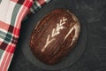 Freshly baked warm delicious rye round bread close-up and a kitchen checkered towel. The concept of healthy eating