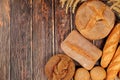 Freshly baked whole grain homemade bread, assorted varieties of round sourdough bread with crispy crust and ears of rye and wheat Royalty Free Stock Photo