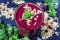 Freshly blended berry smoothie in a glass and granola on dark rustic wooden background. Selective focus, copy space