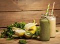 Freshly blended green and banana smoothies in glass bottles with straws. Royalty Free Stock Photo