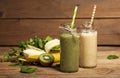 Freshly blended green and banana smoothies in glass bottles with straws. Royalty Free Stock Photo