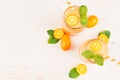 Freshly blended orange citrus kumquat fruit smoothie in glass jars with straw, mint leaf, cute ripe berry, top view. Royalty Free Stock Photo