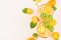 Freshly blended orange citrus kumquat fruit smoothie in glass jars with straw, mint leaf, cute ripe berry, top view. Royalty Free Stock Photo