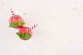 Freshly blended red strawberry fruit smoothie in glass jars with straw, mint leaf, top view. White wooden board background, copy s