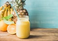 Freshly blended yellow and orange fruit smoothie in glass jar with straw Royalty Free Stock Photo