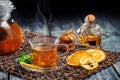 Freshly brewed black tea with mint and cookies, honey and glass teapot on a wooden table