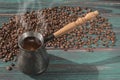 Freshly brewed coffee in cezve jezve and scattered coffee beans Royalty Free Stock Photo