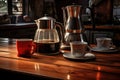 freshly brewed coffee pot alongside empty mugs on a table
