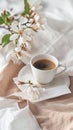 Freshly brewed coffee in a white cup, set on a table with soft linen and white blooms
