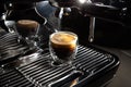 Freshly brewed creamy espresso in a transparent coffee cup placed on a manual coffee machine, close up