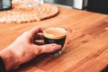 Freshly brewed espresso coffee with hand Royalty Free Stock Photo