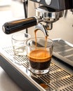 Freshly brewed espresso pouring from chrome machine into crystal glass Royalty Free Stock Photo