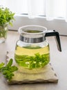 A freshly brewed glass pot of herbal mint tea