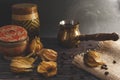 Freshly brewed hot coffee with steam in traditional turkish cezve. Physalis and coffee beans lie on the wooden vintage table. Royalty Free Stock Photo