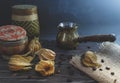 Freshly brewed hot coffee with steam in traditional turkish cezve. Physalis and coffee beans lie on the wooden vintage table. Royalty Free Stock Photo