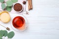 Freshly brewed rooibos tea, dry leaves, honey and spices on white wooden table, flat lay. Space for text