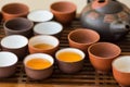 Freshly brewed tea poured in ceramic cups pot utensils on wooden bamboo dripping tray. Chinese Japanese ceremony. Lifestyle