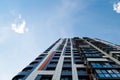 freshly built high rise apartment building on blue sky background with white clouds Royalty Free Stock Photo