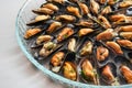 Freshly cooked blue mussels with onion and herbs served on a glass plate