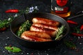 Freshly cooked butchers sausages in skins in cast iron frying pan with Sanford orchards apple cider, Devon, United