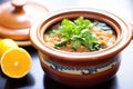 freshly cooked lentil soup in a clay pot with a lid