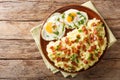 Freshly cooked mashed potatoes with bacon and parsley served with fried eggs close-up on a plate. Horizontal top view