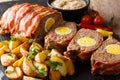 Freshly cooked meat loaf with egg wrapped in bacon with potato w Royalty Free Stock Photo