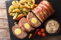 Freshly cooked meat loaf with egg wrapped in bacon with potato w Royalty Free Stock Photo