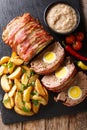 Freshly cooked meat loaf with egg wrapped in bacon with potato w Royalty Free Stock Photo