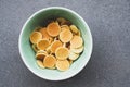 Freshly cooked pancake cereal in a bowl on grey concrete background.