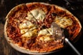 Freshly cooked pizza. Cut into pieces. Dark background. Close-up