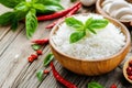 Freshly cooked rice in a black bowl with basil and red chili on rustic wooden table Royalty Free Stock Photo