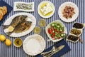 Freshly cooked seafood grilled sea bream fishes, octopus in vinegar sauce, sardines in olive oil and vegetable salad Royalty Free Stock Photo