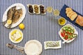 Freshly cooked seafood grilled sea bream fishes, sardines in olive oil and vegetable salad, olives, feta cheese, bread Royalty Free Stock Photo