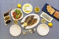 Freshly cooked seafood grilled sea bream fishes, sardines in olive oil and vegetable salad, olives, feta cheese, bread Royalty Free Stock Photo