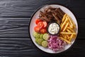 Freshly cooked shawarma plate with beef, french fries, vegetables and sauce close-up. horizontal top view Royalty Free Stock Photo