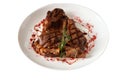 Freshly cooked t-bone steak sprinkled with spices and garnished with a sprig of rosemary on a round white plate isolated. Royalty Free Stock Photo